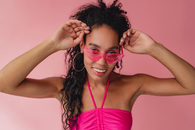 Atractiva mujer afroamericana negra con traje elegante de fondo rosa