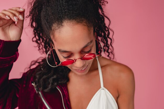 Atractiva mujer afroamericana negra con traje elegante de fondo rosa