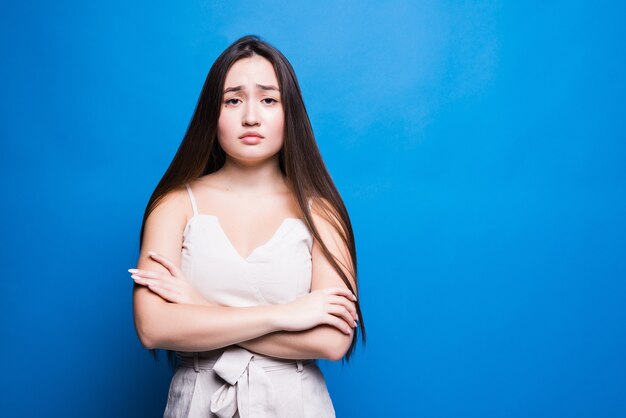 Atractiva mujer asiática que se encuentran aisladas en la pared azul