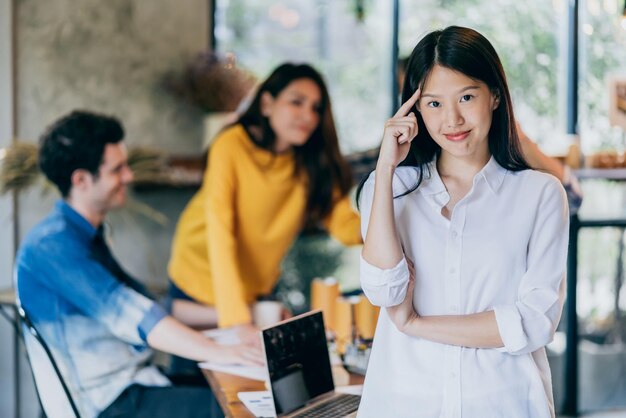 Atractiva mujer asiática sonríe con felicidad y confianza con el trabajo en equipo reuniéndose con el concepto de ideas de inicio de fondo