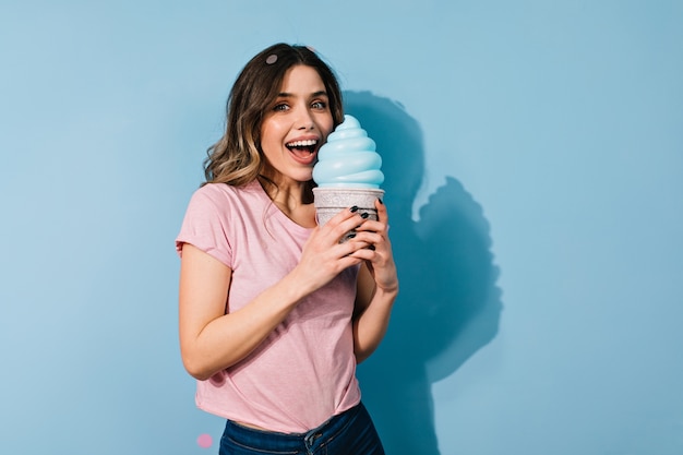 Foto gratuita atractiva mujer de cabello castaño sosteniendo gran helado