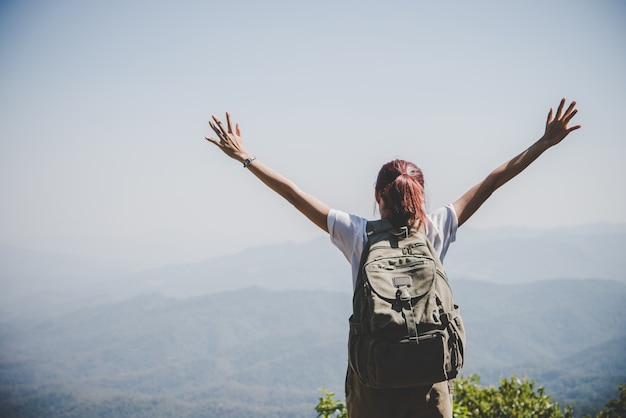 Foto gratuita atractiva mujer caminante brazos abiertos en el pico de montaña, disfrutar con la naturaleza. concepto de viaje.