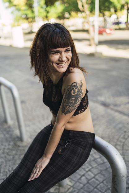 Atractiva mujer caucásica joven con tatuajes en la calle