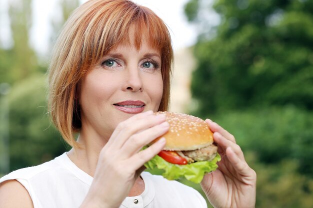 Atractiva mujer comiendo en un parque