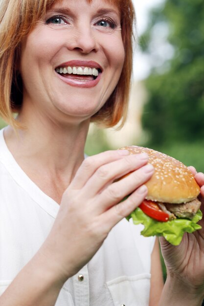 Atractiva mujer comiendo en un parque