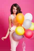 Foto gratuita atractiva mujer elegante posando con globos