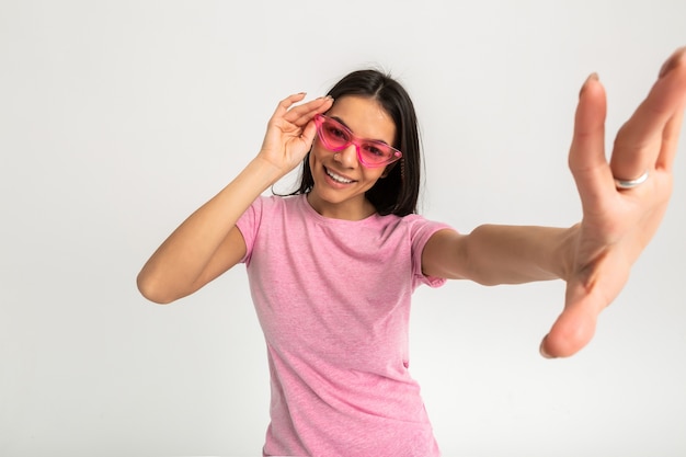 Atractiva mujer emocional divertida feliz en camiseta rosa brazos aislados hacia adelante