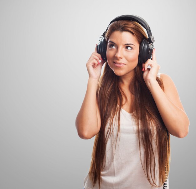 Atractiva mujer escucha la música en los auriculares