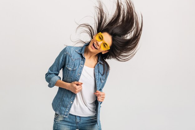 Atractiva mujer feliz sonriente bailando agitando el pelo largo aislado en blanco studio