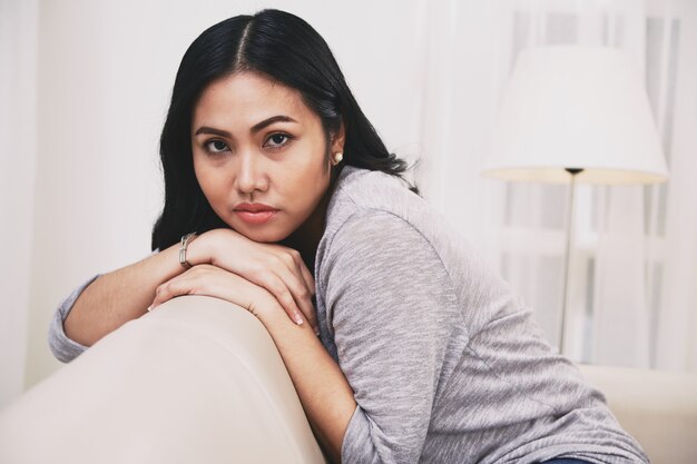 Atractiva mujer filipina descansando en el sofá