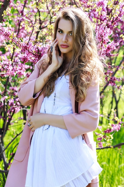 Atractiva mujer joven y bonita en vestido blanco claro