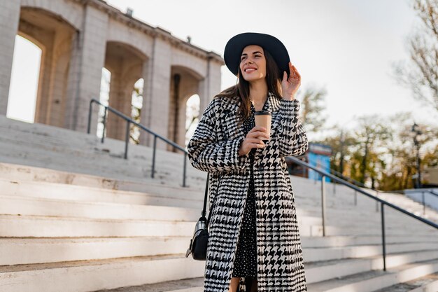 Atractiva mujer joven caminando en otoño con abrigo