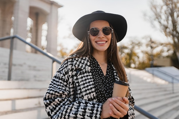 Atractiva mujer joven caminando en otoño con abrigo