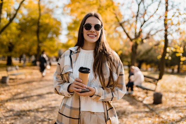 Atractiva mujer joven caminando en otoño con chaqueta