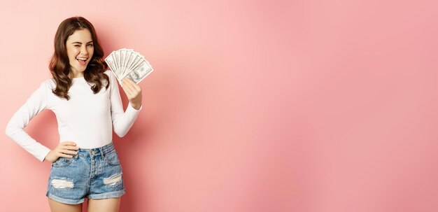 Foto gratuita atractiva mujer joven con dinero en efectivo en manos concepto de préstamos de microcrédito y standin de compras