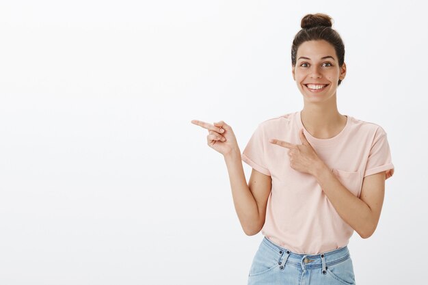 Foto gratuita atractiva mujer joven con estilo posando contra la pared blanca