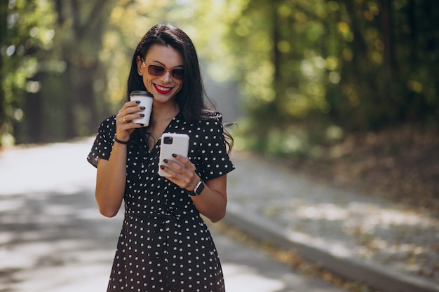 Atractiva mujer joven hablando por teléfono en el parque