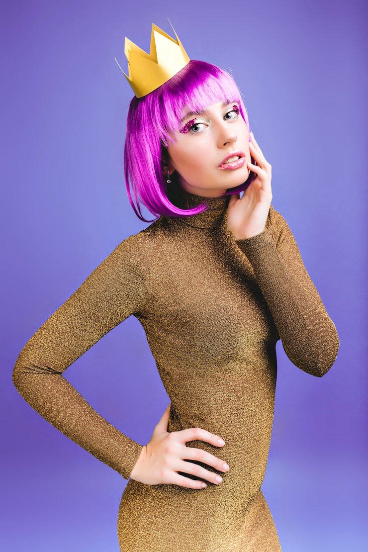 Foto gratuito atractiva mujer joven de moda en elegante vestido de lujo, corte de pelo rosa. maquillaje brillante con oropel, look sexy serio, corona dorada, celebración.