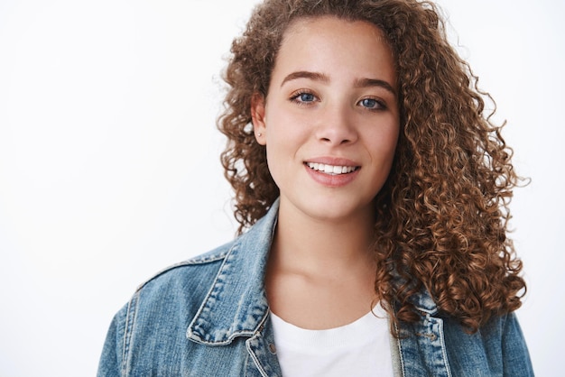 Atractiva mujer joven tierna de pelo rizado gordita sonriente mirada tonta cámara ojos azules novia asistir a la primera cita gustar pasar tiempo juntos novio divertirse mirar feliz fondo blanco