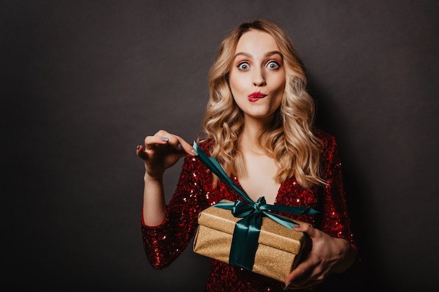 Atractiva mujer joven tocando la cinta de regalo de año nuevo