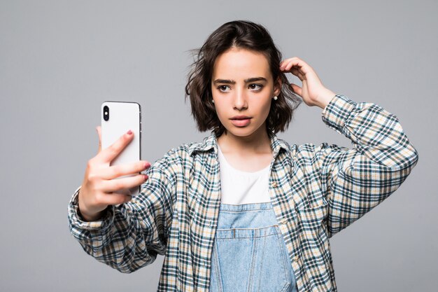 Atractiva mujer joven tomando selfie con teléfono