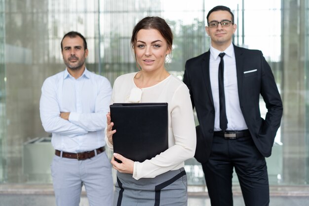 Atractiva mujer de negocios sonriente y dos socios i