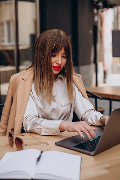 Atractiva mujer de negocios trabajando en equipo en un café