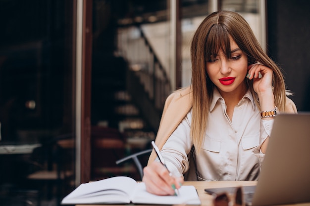 Atractiva mujer de negocios trabajando en equipo en un café