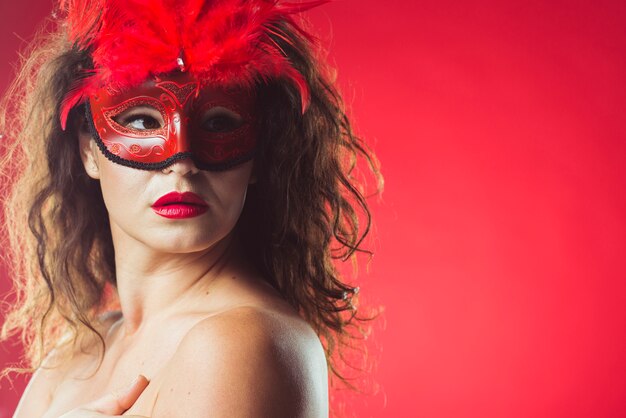 Atractiva mujer sensual en máscara roja