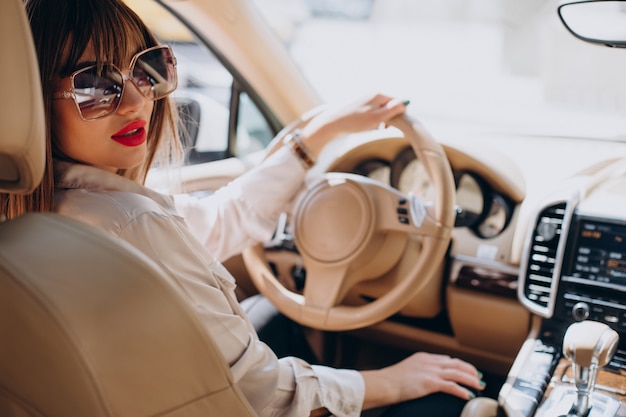 Atractiva mujer sentada en su coche