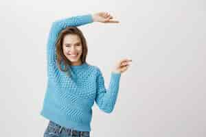 Foto gratuita atractiva mujer sonriente y feliz señalando con el dedo a la derecha