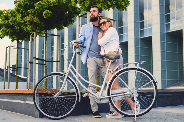 Atractiva pareja en una cita después de andar en bicicleta en una ciudad.