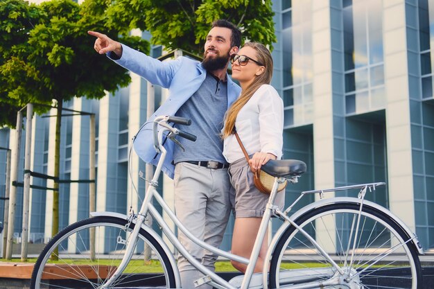 Atractiva pareja en una cita después de andar en bicicleta en una ciudad.