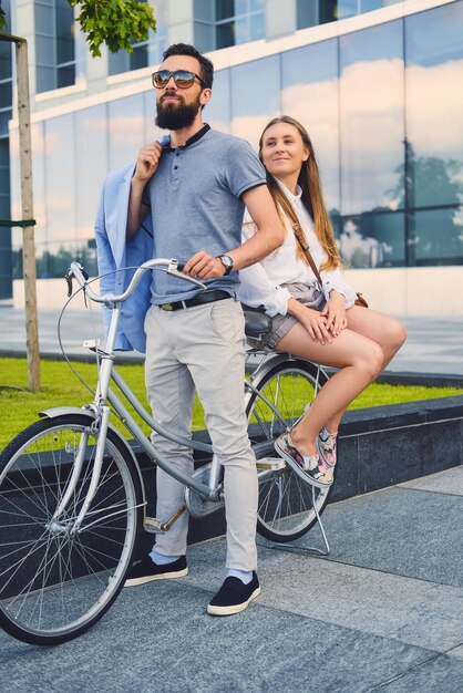 Atractiva pareja en una cita después de andar en bicicleta en una ciudad.