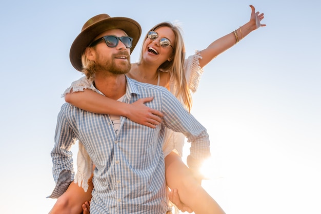 Atractiva pareja feliz riendo viajando en verano por mar, hombre y mujer con gafas de sol