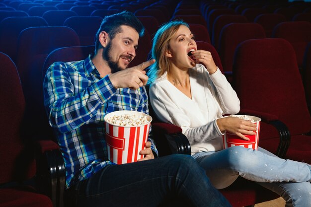 Atractiva pareja joven viendo una película en un cine