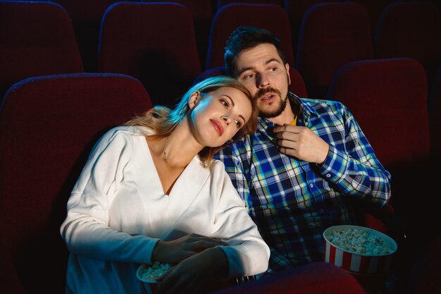 Atractiva pareja joven viendo una película en un cine