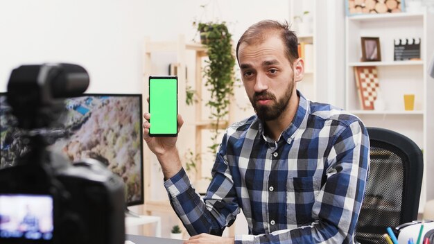 Atractiva revisión de grabación de influencer del teléfono con pantalla verde. Vlogger famoso.