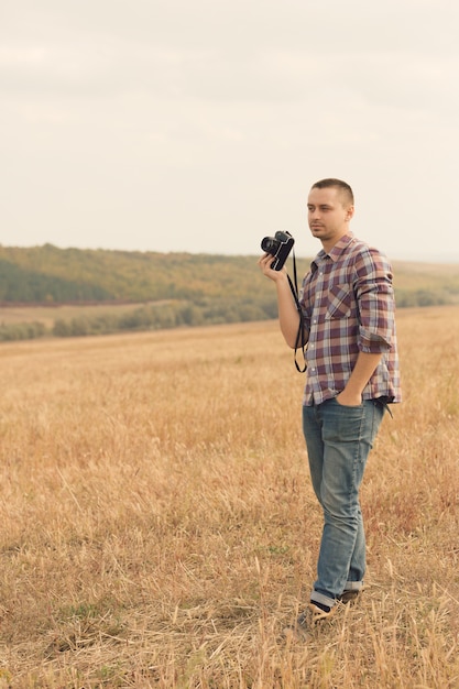 Atractivo fotógrafo masculino al aire libre al atardecer