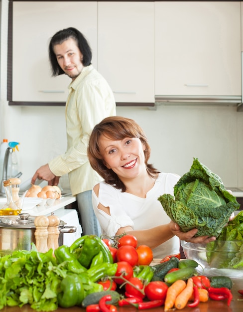 Un atractivo hombre y mujer con verduras en la cocina