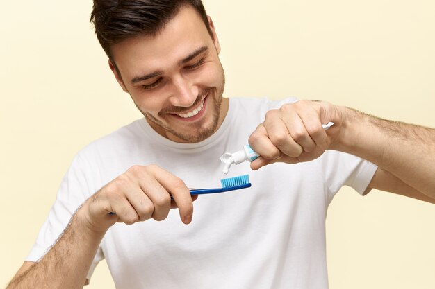 Atractivo joven barbudo se cepilla los dientes