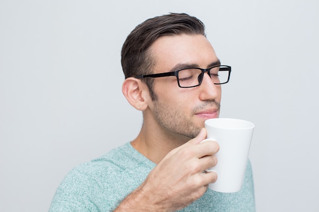 Foto gratuita atractivo joven disfrutando de olor de té