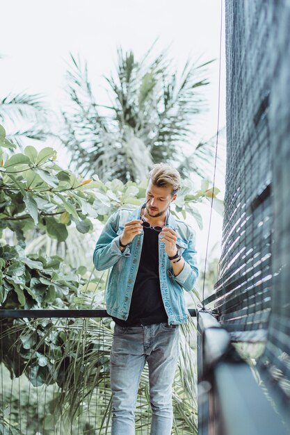 atractivo joven posando en un lugar tropical, sobre un fondo de palmeras y vegetación