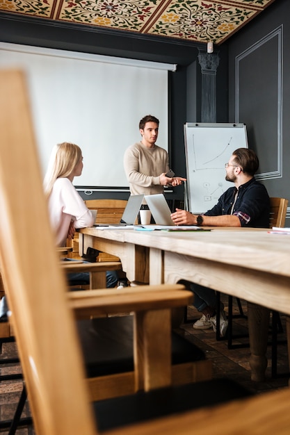 Atractivos colegas trabajan con computadoras portátiles y portátiles.