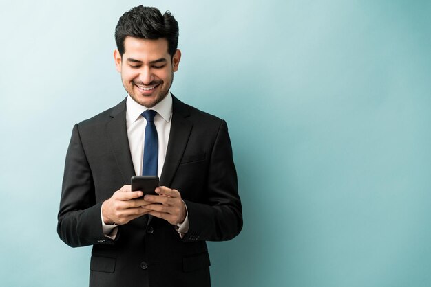 Atractivos mensajes de texto de empresarios latinos a través de teléfonos móviles con fondo de color