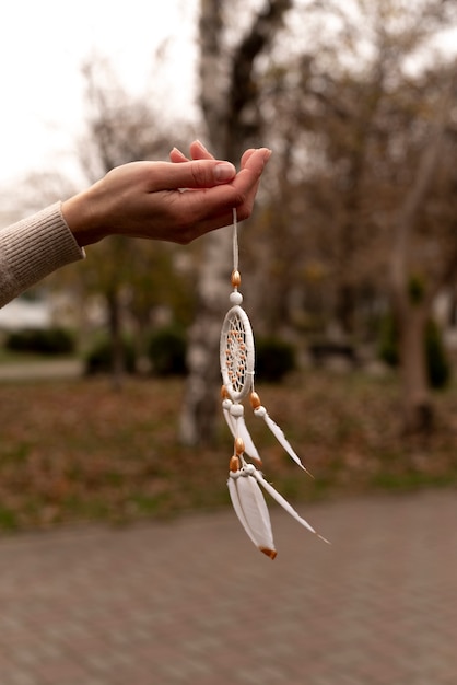 Foto gratuita atrapasueños sostenido con la mano al aire libre