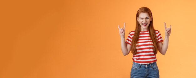 Foto gratuita atrevida pelirroja emocionada y atrevida mujer divirtiéndose disfrutando de un concierto de rock and roll impresionante sonriendo emoción