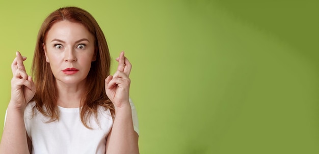 Foto gratuita aturdida intensamente preocupada mujer pelirroja de mediana edad mira nerviosamente esperando un resultado importante implorar d