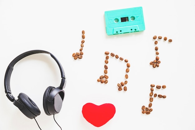 Auricular; forma de corazón; Cassette turquesa y granos de café sobre blanco