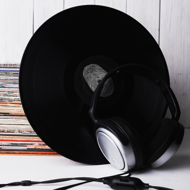 Auriculares close-up cerca de disco de vinilo con huella digital